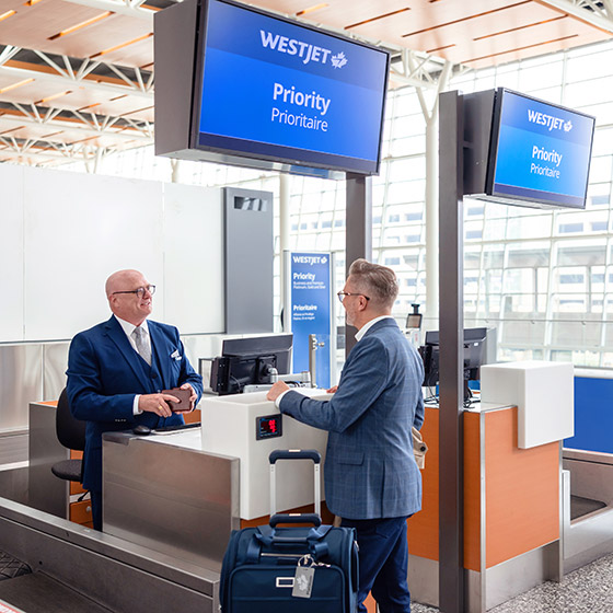 WestJetter greeting guest at Priority check-in counter. WestJetter greeting guest at Priority check-in counter.