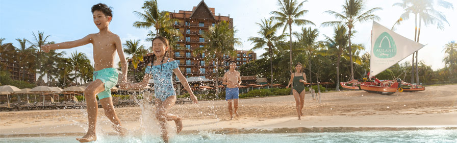 Family running into ocean at Aulani, A Disney Resort & Spa